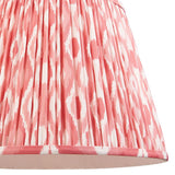 Close-up of Endon Brackmont Ikat Coral pendant shade, showing handmade pleated faux silk in coral pink and white Ikat print with taped edge trim.