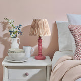 Endon Aldworth Ikat table lamp with pink turned spindle base and pleated ikat shade on a white bedside drawer in a soft pink bedroom.