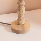 Close-up of the Endon Aldworth table lamp's hand-turned natural wood spindle base with grey braided fabric flex on a light neutral surface.