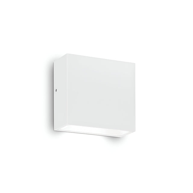 The Sparka-1 Outdoor Wall Light is a minimalist, white, wall-mounted cube fixture featuring a downward-facing bulb that showcases modern lighting design. Perfect for contemporary spaces, this IP44-rated piece offers both durability and style against a plain white background.
