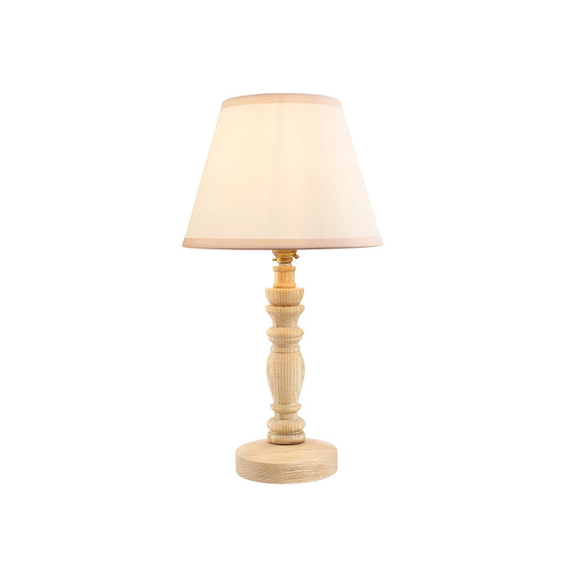 Endon Aldworth table lamp with turned natural ash spindle base, brass B22 lamp holder and tapered vintage white cotton shade on a plain background.