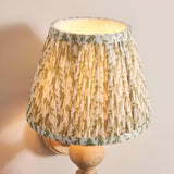 Endon Aldworth Leaf wall light with a pleated tapered shade in herb green leaf print, mounted on a turned natural ash spindle base.