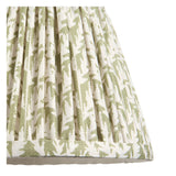 Close-up of the Endon Aldworth wall light's pleated tapered shade in herb green leaf-print faux linen with taped edge trim.