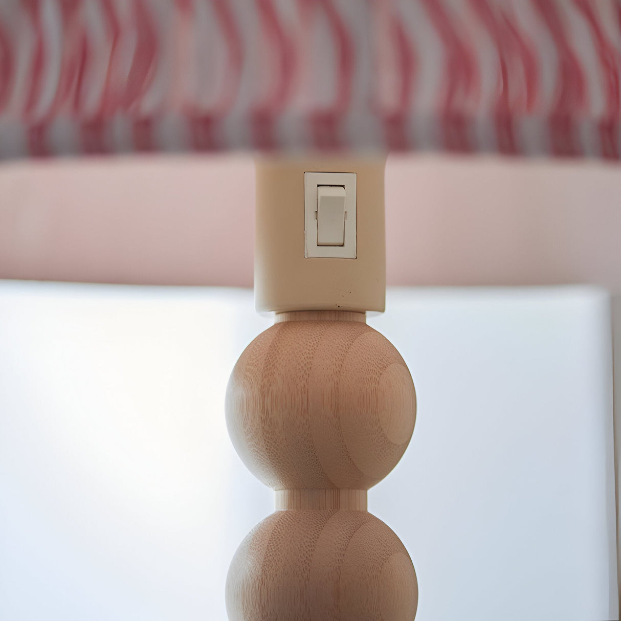 Close-up of the Endon Ashwood floor lamp showing the cream E27 lamp holder with rocker switch above stacked natural bamboo spheres and pink pleated shade.