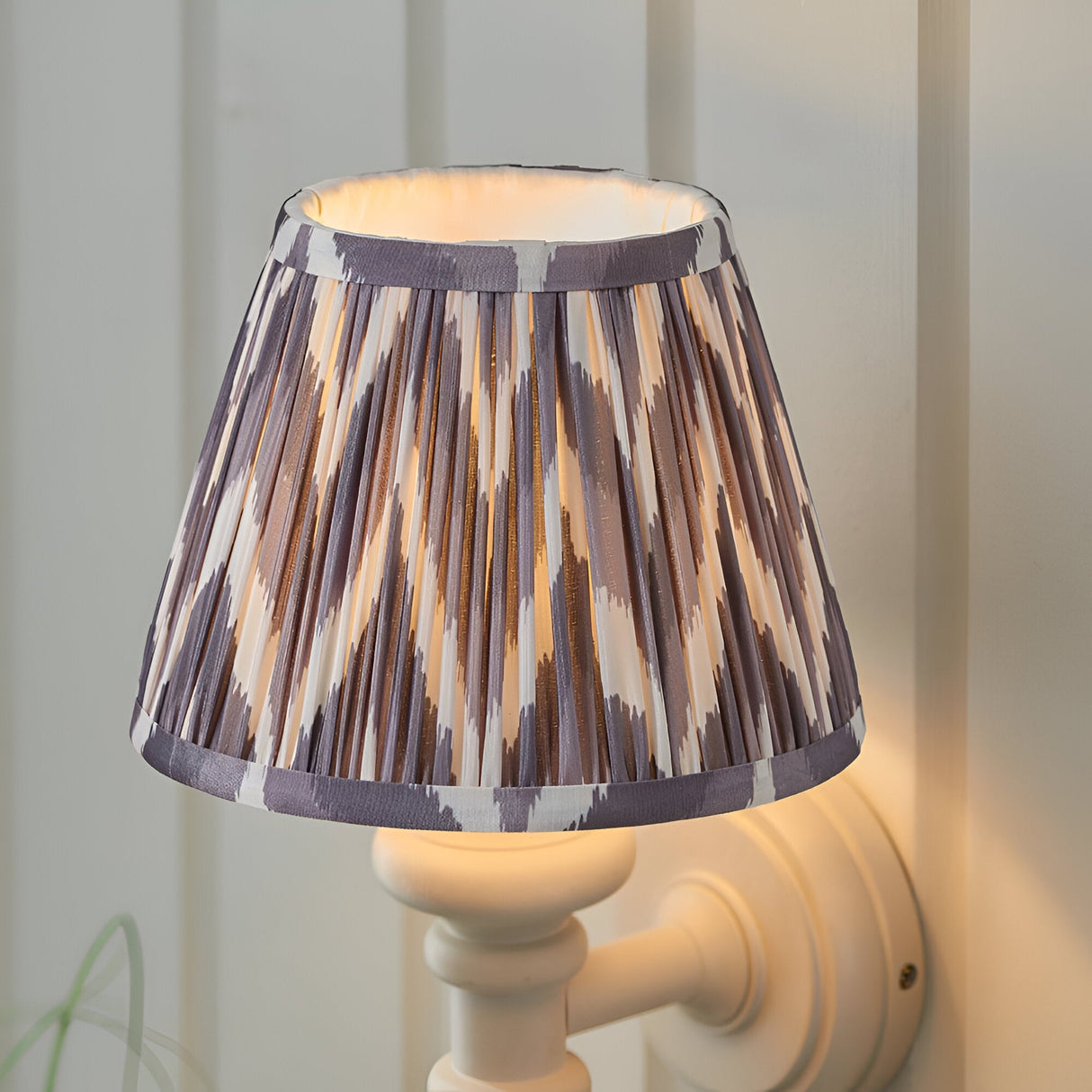 Endon Bevbury Zigzag wall light with white turned wood spindle, brass B22 lamp holder and grey and white pleated faux silk zigzag shade.