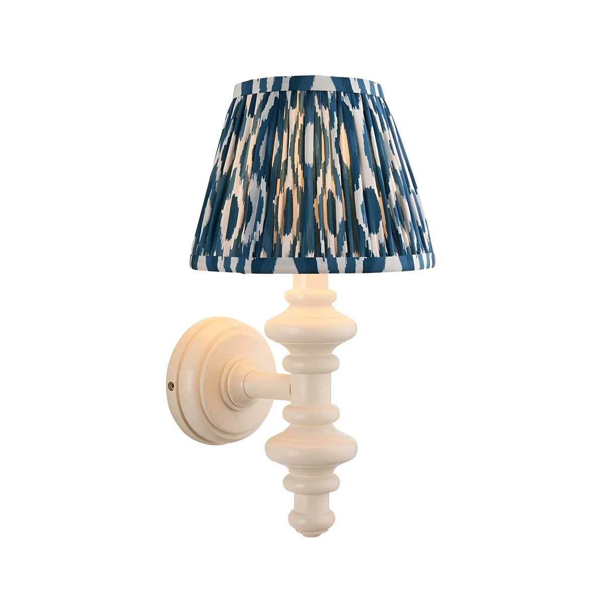 Bevbury Ikat wall light with a turned white spindle base, brass B22 lamp holder, and pleated blue and white Ikat-pattern shade, shown on a plain background.