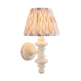 Endon Bevbury Ikat wall light with a white turned wooden spindle, brass B22 lamp holder and tapered pleated Ikat shade in pink and natural tones.