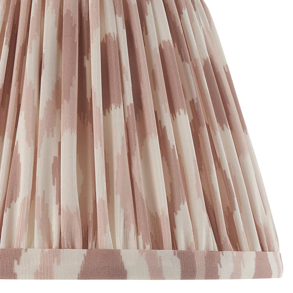 Close-up of the Endon Bevbury Ikat wall light's tapered pleated faux silk shade, showing the pink clay and cream ikat print pattern.