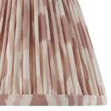 Close-up of the Endon Bevbury Ikat wall light's tapered pleated faux silk shade, showing the pink clay and cream ikat print pattern.