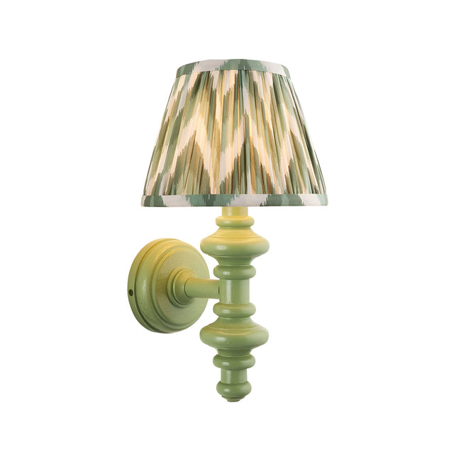 Endon Bevbury Zigzag wall light with green turned wooden spindle and tapered pleated shade in green and cream zigzag print, on a white background.