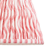 Close-up of the Endon Bevbury Ripple wall light's gathered tapered shade in faux linen with a pink rippling pattern on a white ground.