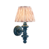 Endon Bevbury Ikat wall light with turned blue wooden spindle, brass B22 holder and tapered pleated pink ikat faux silk shade on a white background.