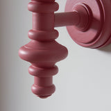Close-up of the Endon Bevbury Ripple wall light showing the pink clay satin-painted turned wooden spindle and circular wall plate against a light background.