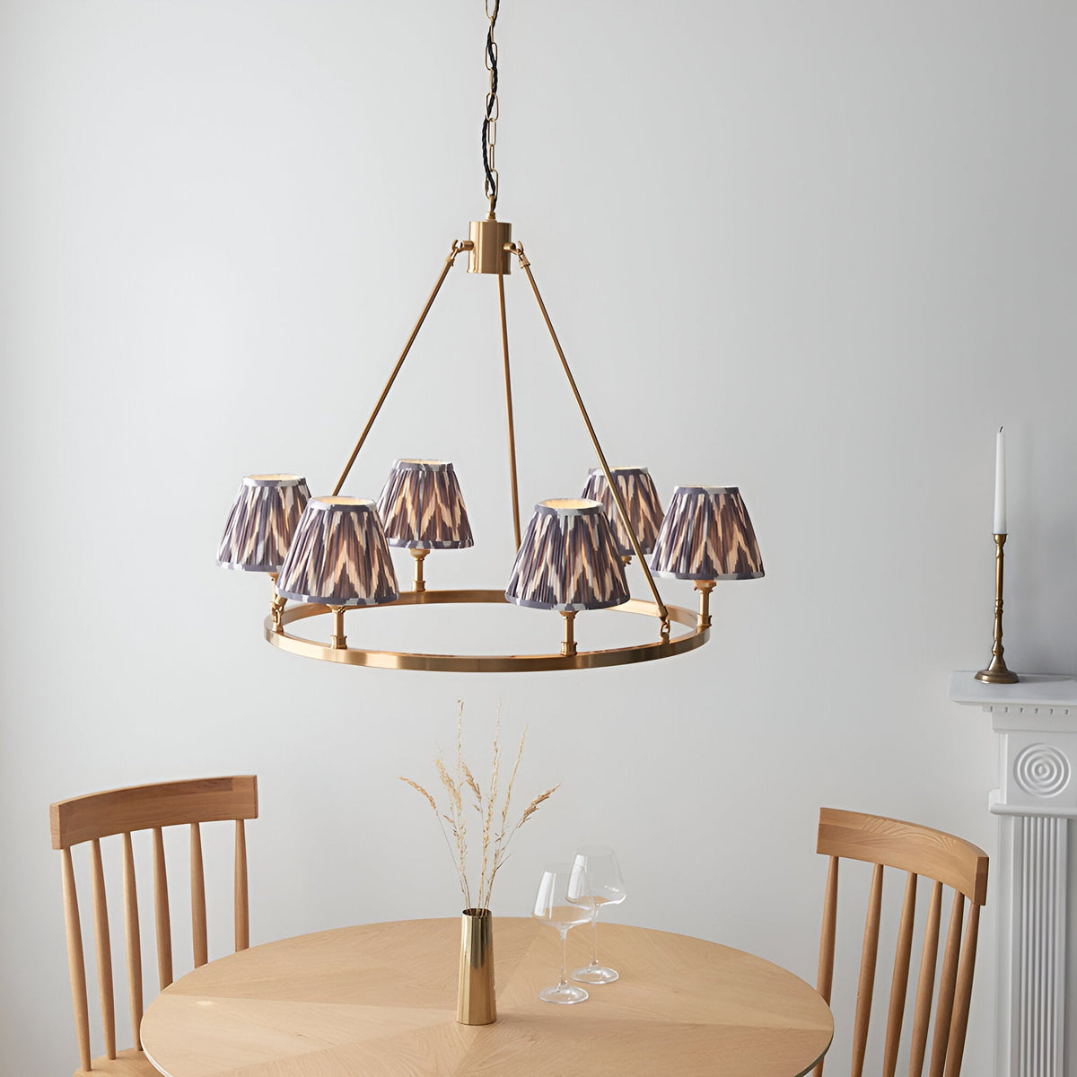Endon Bevford Zigzag six-light pendant with aged brass hoop frame and pleated grey zigzag fabric shades, hung above a wooden dining table.
