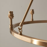 Close-up of the Bevford Ikat 6 Light Pendant's aged brass hoop frame with B22 lamp holders and a hook-and-rod support, shown against a plain background.
