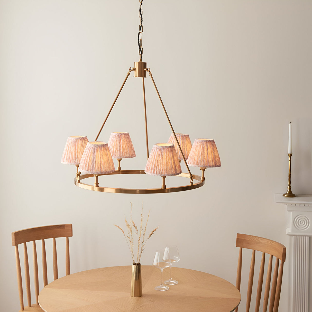 Endon Bevford six-light hoop pendant in aged brass with pleated peach leaf-print faux linen shades, shown above a wooden dining table.