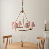 Endon Bevford Leaf 6 light pendant with aged brass hoop and pleated peach faux linen shades, above a wooden dining table and chairs.