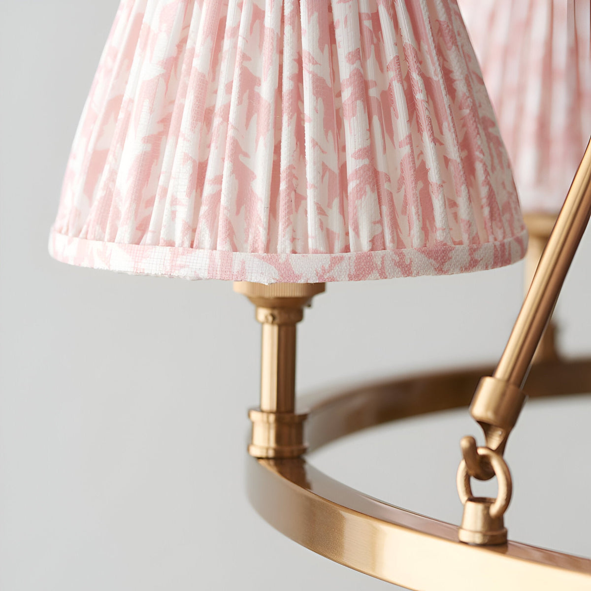 Close-up of the Endon Bevford Leaf pendant showing pleated peach faux linen shades with leaf print on an aged brass hoop frame.