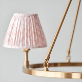Close-up of Endon Bevford 3 Light Pendant in peach, showing an aged brass hoop with a pleated pink patterned fabric shade on a B22 lamp holder.