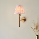 Bevford Leaf Wall Light in aged brass finish with a pleated tapered pink leaf-patterned fabric shade, shown against a plain light background.