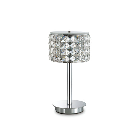 The Nebula Table Lamp - Chrome showcases a contemporary design with a cylindrical, diamond-patterned glass shade adorned with crystal accents, all resting on a sleek metal stand and base, presented against a plain white background.