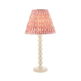 Endon Brenleigh Ripple table lamp with stacked-sphere white gloss metal base and pink and white pleated faux linen shade, on a plain background.