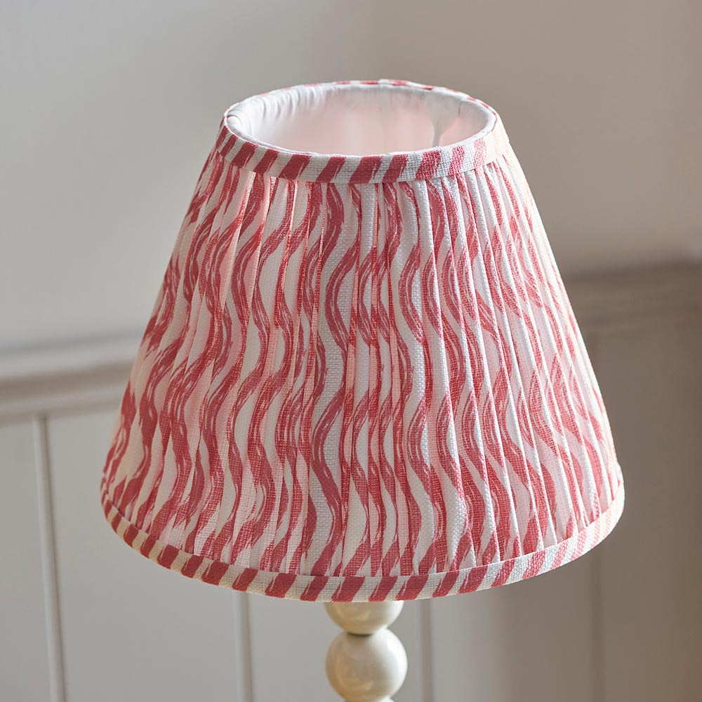 Endon Brenleigh Ripple table lamp shade in pleated white and pink faux linen with a wavy stripe print, shown on a cream stacked-sphere base.