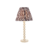 Brenleigh Ikat table lamp with a gloss white stacked-sphere metal base and a pleated grey-toned Ikat print fabric shade, shown on a plain white background.