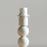 Brenleigh Ikat table lamp base close-up with stacked gloss white spheres and E14 bulb holder, on a plain light grey background.