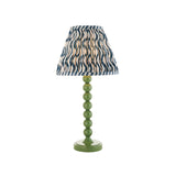 Endon Brenleigh Ripple table lamp with a green stacked-sphere metal base and blue and white pleated ripple fabric shade on a plain background.