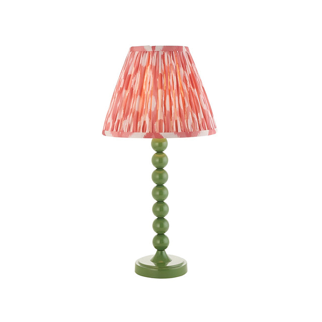 Endon Brenleigh Ikat table lamp with a green stacked-sphere metal base and pink pleated ikat faux silk shade on a white background.