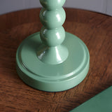 Close-up of the Brenleigh Zigzag Table Lamp's stacked-sphere metal base in gloss green, shown on a wooden tray surface.