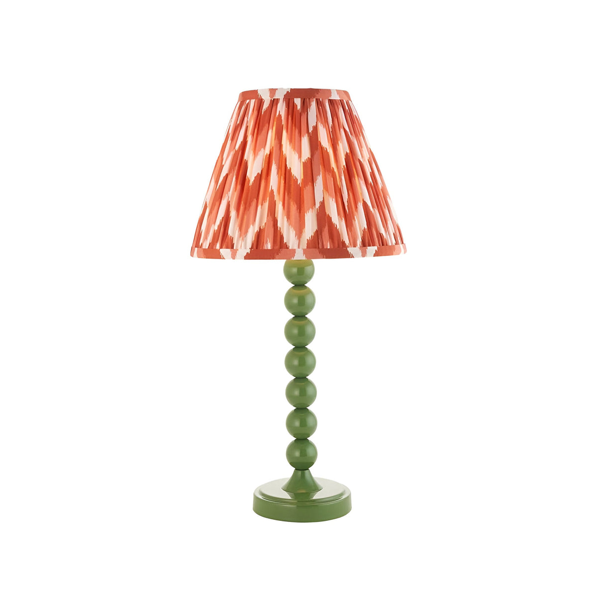 Brenleigh Zigzag table lamp with a green stacked-sphere metal base and a pleated orange zigzag-print fabric shade, shown on a plain white background.