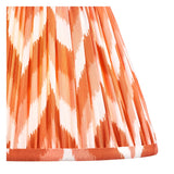 Close-up of the Brenleigh Zigzag Table Lamp's pleated fabric shade, showing an orange and cream zigzag pattern on a plain background.