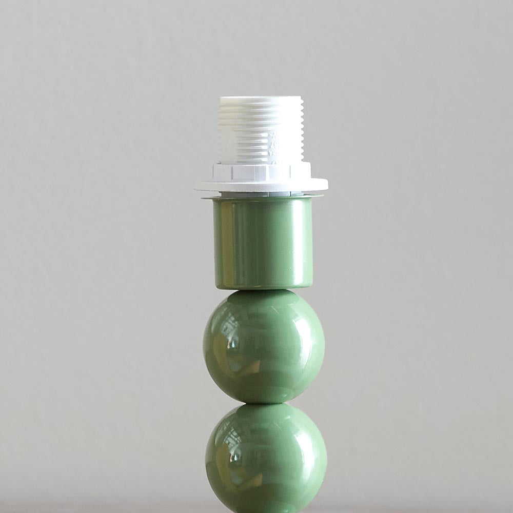 Brenleigh Ikat table lamp base in glossy green stacked-sphere metal with white E14 bulb holder, shown against a plain light grey background.