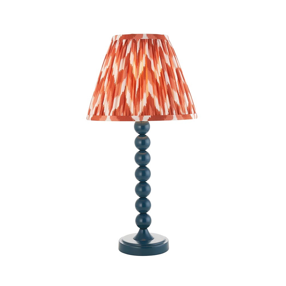 Brenleigh Zigzag Table Lamp in blue, with a stacked-sphere gloss metal base and a pleated orange zigzag-print fabric shade, on a plain white background.