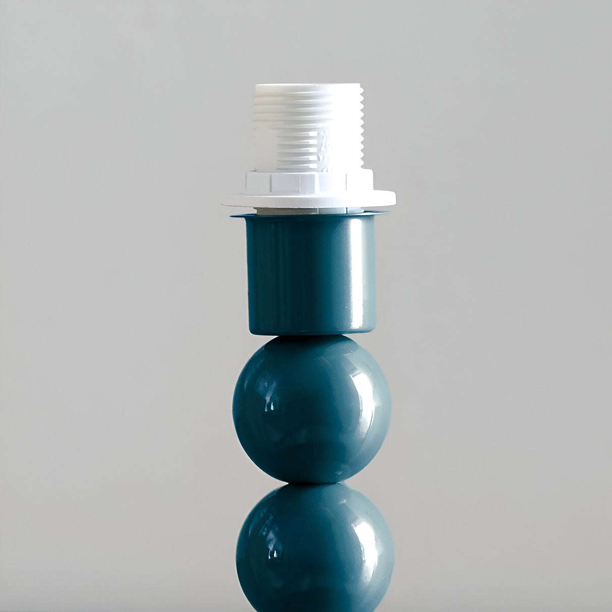 Brenleigh Ivy Table Lamp base in blue with stacked-sphere metal design and white E14 bulb holder, shown against a plain light grey background.
