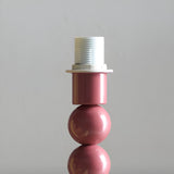 Endon Brenleigh Ripple table lamp base close-up showing glossy pink stacked-sphere metal design with white E14 bulb holder on a light grey background.