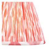 Close-up of the Endon Brenleigh Ikat table lamp's hand-pleated faux silk shade in pink, coral and cream Ikat print with taped edge detailing.