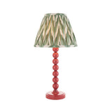 Endon Brenleigh Zigzag table lamp with pink stacked-sphere gloss metal base and green pleated zigzag-print shade, shown on a white background.