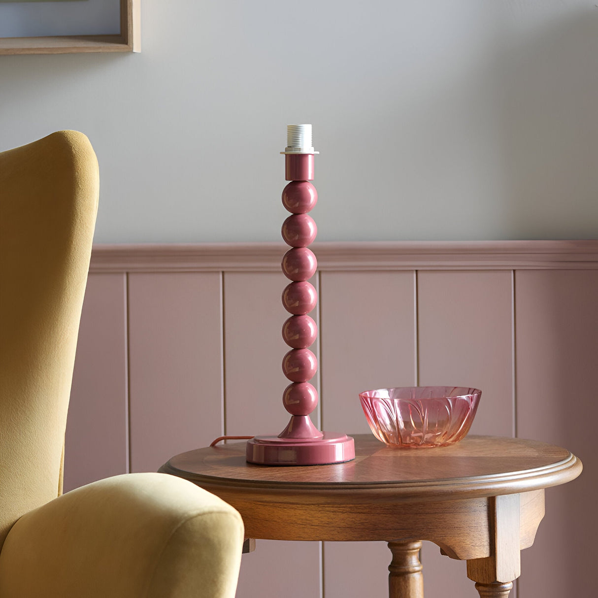 Endon Brenleigh table lamp base with stacked-sphere pink gloss metal column on a wooden side table beside a pink glass bowl in a panelled room.
