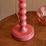 Endon Brenleigh Zigzag table lamp base in gloss pink with stacked sphere design on a wooden side table beside a pink glass bowl.