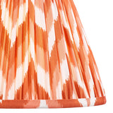 Close-up of the Brenleigh Zigzag Table Lamp's pleated fabric shade in orange and white zigzag pattern with contrasting trim, shown on a white background.