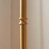 Close-up of the brushed aged brass stem on the Endon Ashstead LED Ripple floor lamp, showing a decorative collar detail against a soft neutral background.