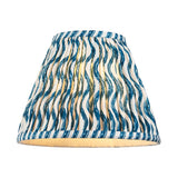 Endon Ashstead Ripple pleated lamp shade in blue and white wavy print with taped edging, shown lit on a plain white background.