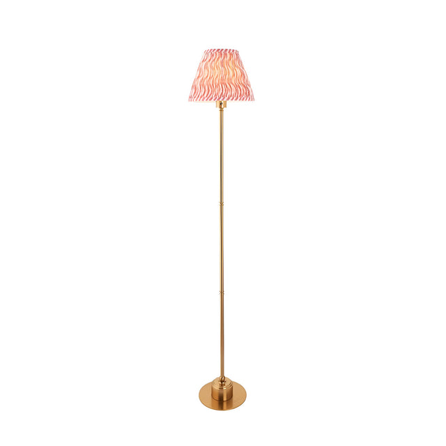 Endon Ashstead LED Ripple floor lamp with brushed aged brass stem and coral pink pleated fabric shade, shown on a plain white background.