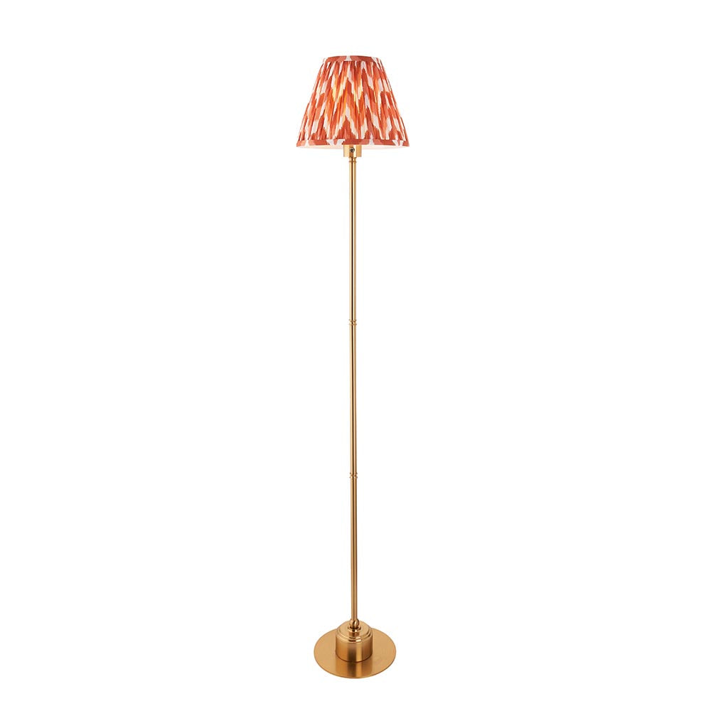 Endon Ashstead LED floor lamp with slim brushed brass stem and apricot orange zigzag pleated shade, shown on a plain white background.