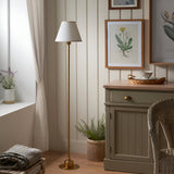 Endon Ashstead LED Ivy floor lamp with vintage white cotton shade and brushed aged brass stem, styled in a cottage corner beside a sideboard and window.