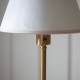 Close-up of the Endon Ashstead LED Ivy floor lamp showing the brushed aged brass stem, touch dimmer button, and vintage white cotton mix shade.