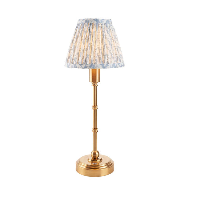 Ashstead LED table lamp with a slender brass stem, round base, and a pleated leaf-print fabric shade in white and blue, shown on a plain white background.